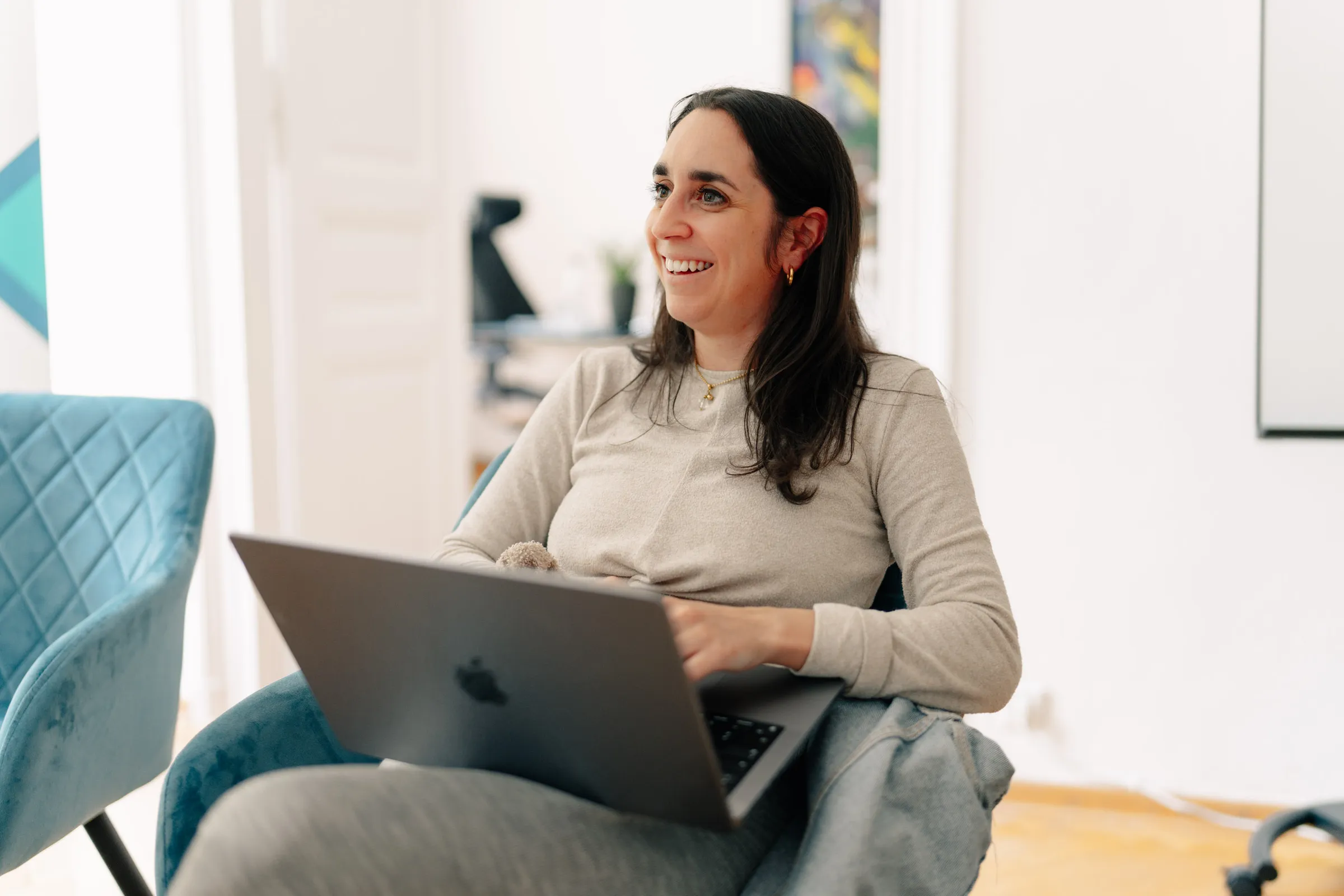 Aviando consultant with a laptop in an armchair, laughing