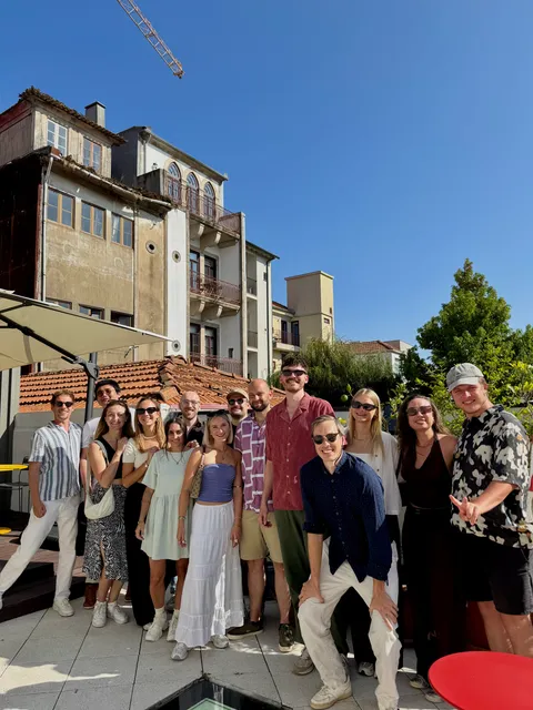 Das Team auf einer sonnigen Dachterrasse beim gemeinsamen Team-Trip