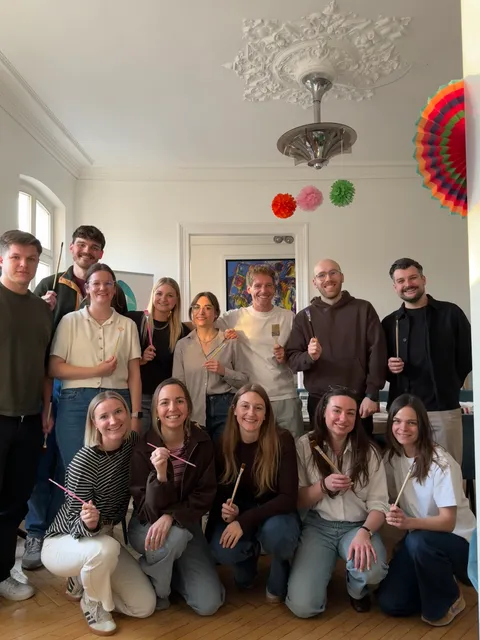 Gruppenfoto mit Pinseln beim gemeinsamen Mal-Event im Büro